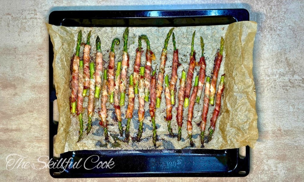 Asparagus roasted with the prosciutto on a baking sheet