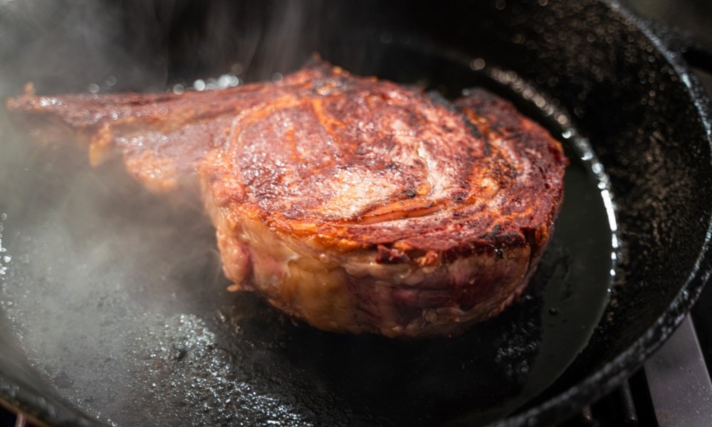 cooking steak on a cast iron pan